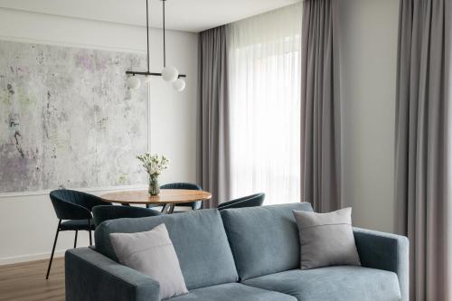 sala de estar con sofá azul y mesa en No. 1 PARK AVENUE APARTMENT, en Kaunas