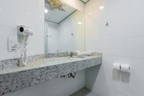 baño con lavabo y teléfono en la encimera en ibis Styles Sao Jose do Rio Preto en São José do Rio Preto