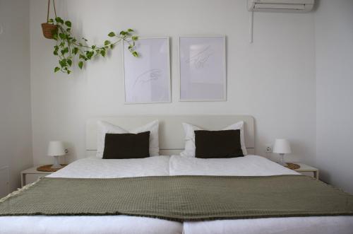 a bedroom with a large white bed with two pillows at Apartments Fink in Portorož