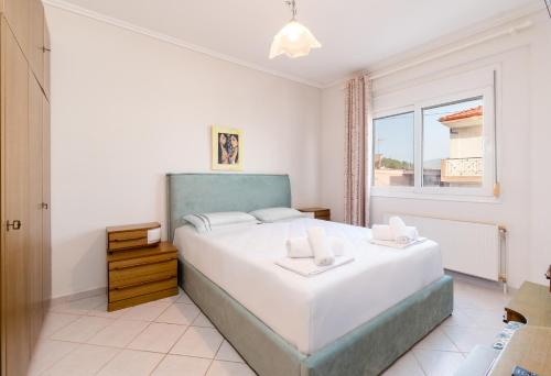Un dormitorio con una cama grande y una ventana en Theophile Apartment en Néos Marmarás