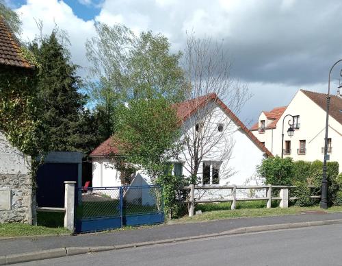 une maison blanche avec une clôture devant dans l'établissement Petite maison près de Disneyland, à Magny-le-Hongre