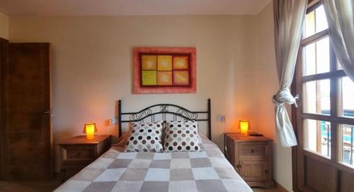 a bedroom with a bed with two lamps and a window at Casa Las Xanas in Llanes