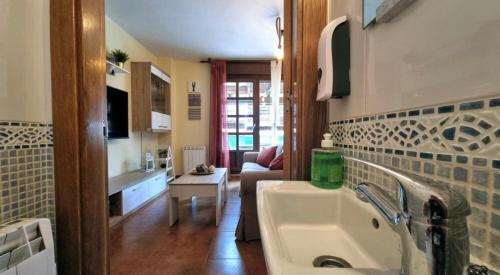 a bathroom with a sink and a living room at Casa Las Xanas in Llanes