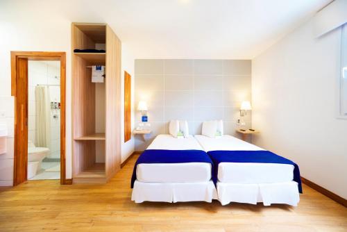 a bedroom with a large bed and a bathroom at LP Equipetrol in Santa Cruz de la Sierra