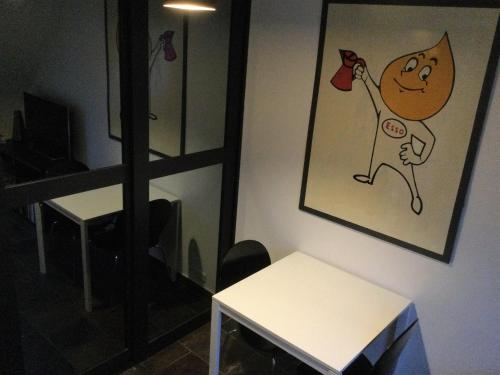 a room with a table and a picture of a cat drinking at Penthouse in the heart of the City in Copenhagen