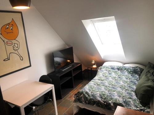 a small bedroom with a bed and a television at Luxury Penthouse in the heart of the City in Copenhagen