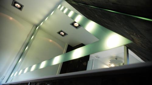 a room with a ceiling with lights and a mirror at Penthouse in the heart of the City in Copenhagen