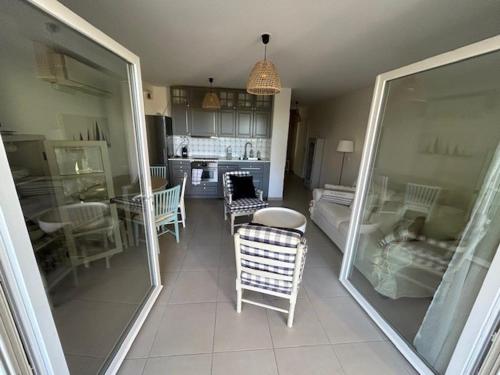 un salon avec des chaises et une table et une cuisine dans l'établissement APPARTEMENT Résidence RIVES D'EDEN, à Sainte-Maxime