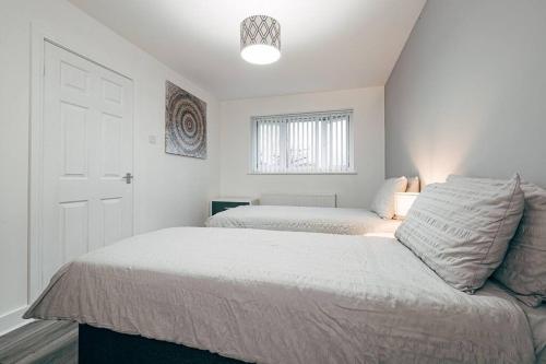 リバプールにあるPark & Relax in 1bd Central Liverpool homeの白いベッドルーム(ベッド2台、窓付)