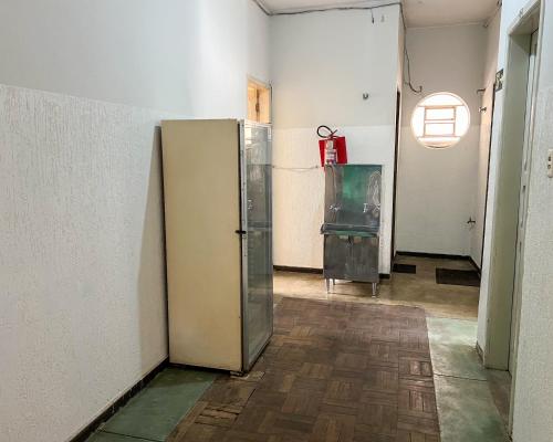 an empty room with a refrigerator and a window at Elite Economy Hotel in Pará de Minas