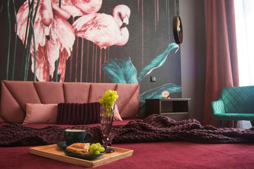 un soggiorno con divano rosa e un vassoio di cibo di Apartamenty Paderewskiego 1 a Bydgoszcz