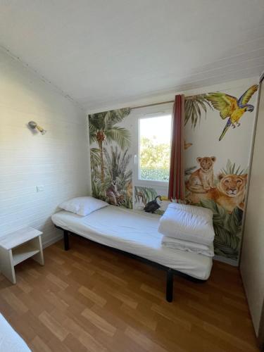 a room with a bed with a painting on the wall at Chalet T3 4/6 personnes à Agde in Agde