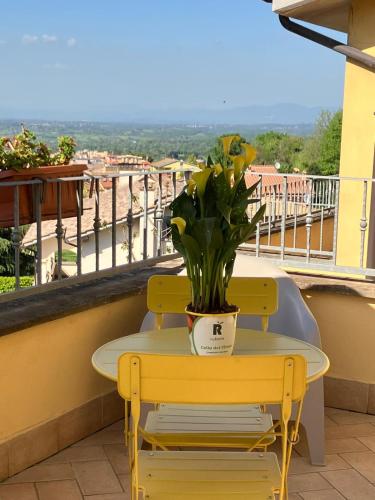 a yellow table and chairs on a balcony with a plant at A casa di Miele in Campagnano di Roma