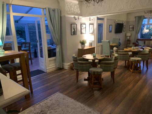 a living room with tables and chairs and a dining room at The Old Coach House in Blackpool