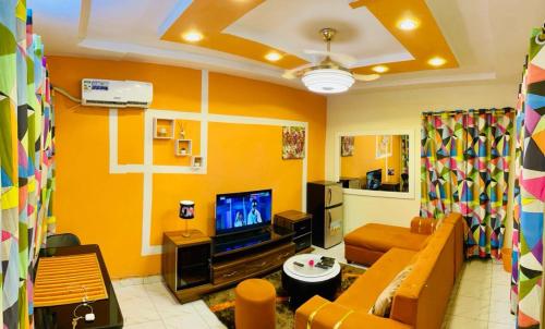 - un salon avec un canapé et une télévision dans l'établissement Seïf Industry's, à Ouagadougou
