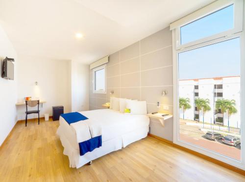 a bedroom with a large bed and a large window at LP Equipetrol in Santa Cruz de la Sierra