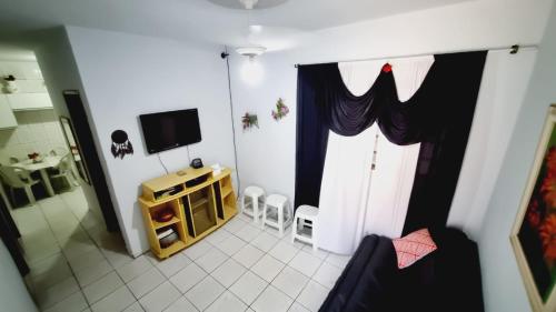 - un salon avec une télévision et une porte avec des rideaux dans l'établissement CASA EM PAULÍNIA, à Paulínia