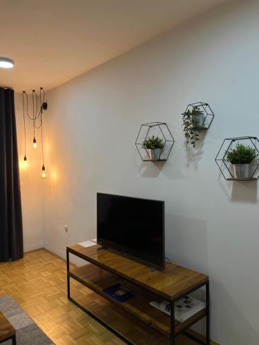 a living room with a flat screen tv on a wall at For5 in Ðakovo