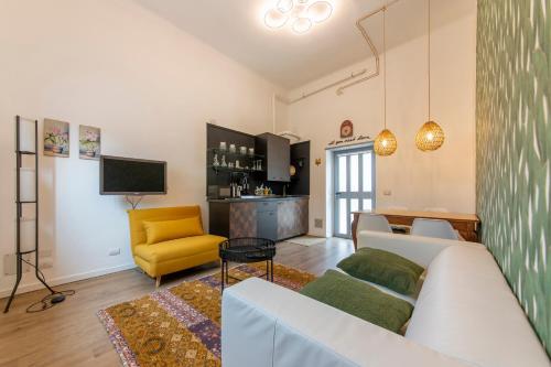 ein Wohnzimmer mit einer weißen Couch und einem gelben Stuhl in der Unterkunft Home Sweet Home in Rho