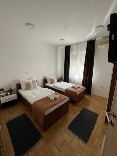 a hotel room with two beds and a television at For5 in Đakovo