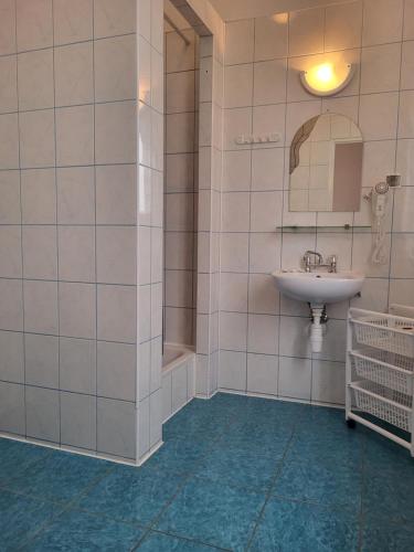 La salle de bains est pourvue d'un lavabo et d'un miroir. dans l'établissement Pałacyk Srebrna Fala, à Międzyzdroje