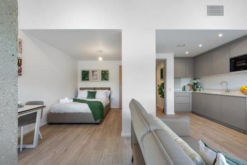 a bedroom and living room with a bed and a kitchen at Stylish 1BR Retreat at Station House Milton Keynes in Milton Keynes