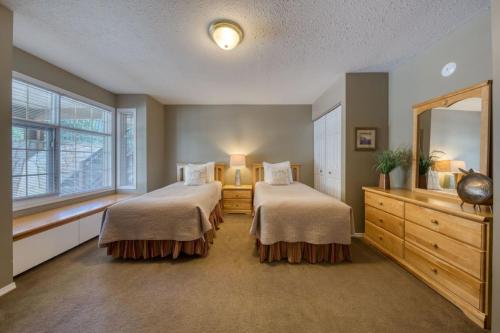a bedroom with two beds and a large mirror at Marble Canyon in Fairmont Hot Springs
