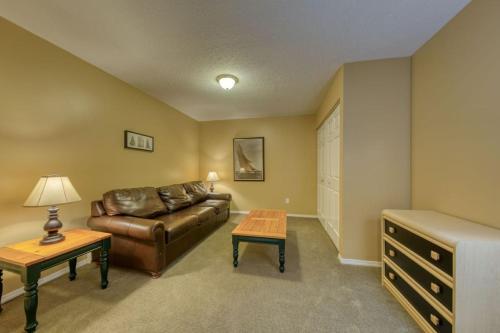 a living room with a leather couch and a table at Marble Canyon in Fairmont Hot Springs