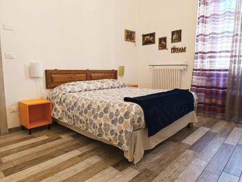 1 dormitorio con 1 cama y suelo de madera en B&B Interno SG, en LʼAquila