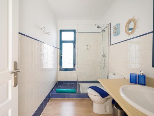 a bathroom with a shower and a toilet and a sink at Villa Bonita in Playa Blanca