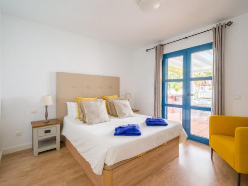 a bedroom with a large bed and a yellow chair at Villa Bonita in Playa Blanca