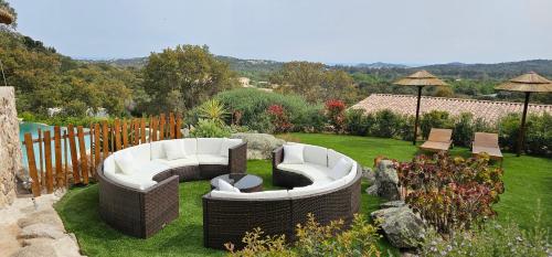 - un jardin avec deux canapés assis sur la pelouse dans l'établissement villas-majos : Magnifique villa vue mer à 3 minutes des plages, à Sainte-Lucie de Porto-Vecchio