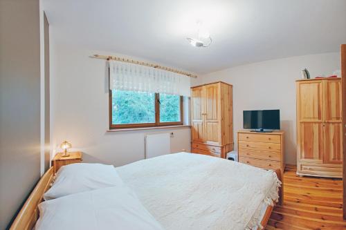 a bedroom with a large bed and a television at Moniuszki, Sun & Snow in Karpacz