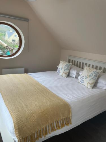 a bedroom with a white bed with a window at Shindilla Cottage Air B&B in Galway