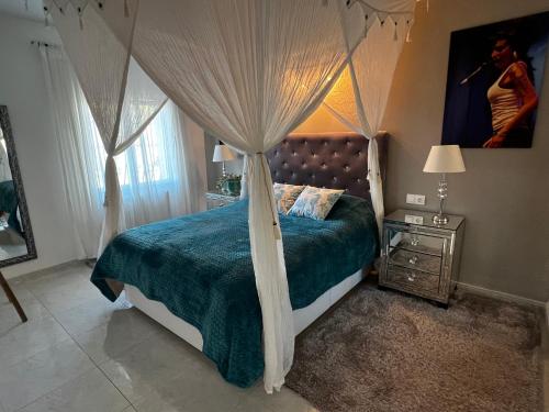 a bedroom with a canopy bed with a blue comforter at Villa Studio44 a Luxury villa in Benissa Costa, max 8 guests, great pool, 700 m2 in Benissa