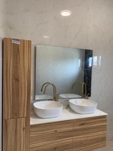a bathroom with two sinks and a large mirror at Luxe Dandji in Cotonou