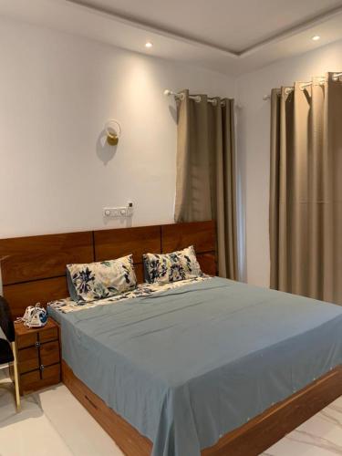 a bedroom with a large bed with blue sheets and pillows at Luxe Dandji in Cotonou