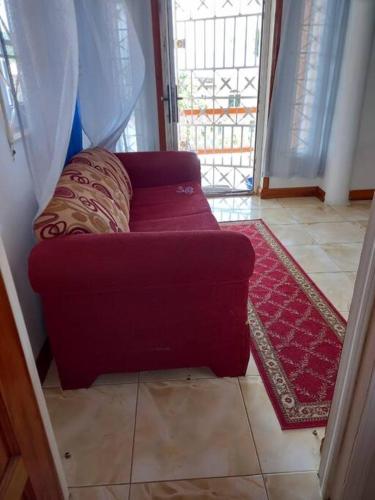 a red couch in a room with a red rug at Kassion Corner Montego bay in Montego Bay