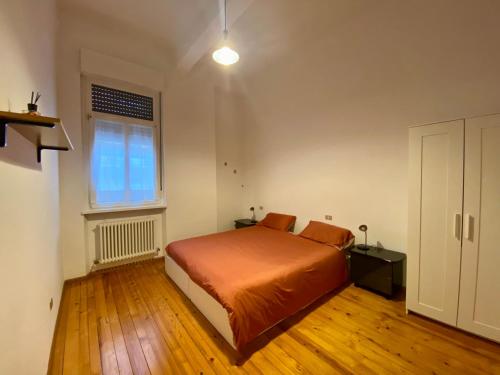 ein Schlafzimmer mit einem orangenen Bett und einem Fenster in der Unterkunft Appartamento a pochi passi dal Duomo in Trient