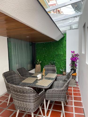 een patio met een tafel en rieten stoelen bij Lili’s room in Quito