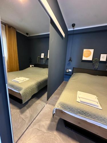 two beds in a room with a mirror at Augustin. welcome home in Duće