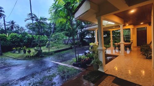 a porch of a house with a table and chairs at Jegers Villa in Negombo