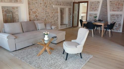 sala de estar con sofá, mesa y sillas en KALAMOS PLAZA en Kálamos