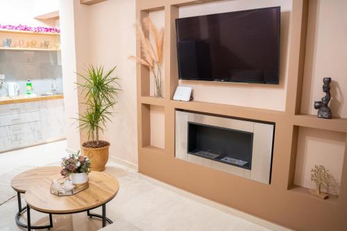 a living room with a flat screen tv above a fireplace at Kostis Luxury Apartment in Agrinion