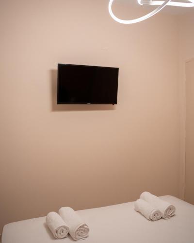 a room with two towels on a bed with a television at Kostis Luxury Apartment in Agrinion