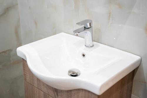 a white sink in a bathroom with a shower at Kostis Luxury Apartment in Agrinion