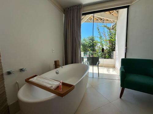 a white bath tub in a bathroom with a window at Passagem Concept Hotel e Spa in Cabo Frio