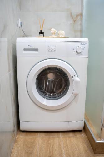 a white washing machine sitting in a room at Kostis Luxury Apartment in Agrinion