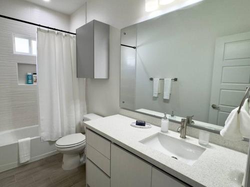 a white bathroom with a sink and a toilet at Brand New Apt! Close to the Mall in McAllen