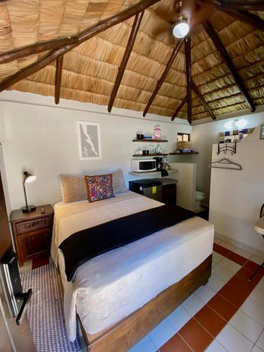 a bedroom with a large bed and a kitchen at Studio Candelero en Loreto in Loreto